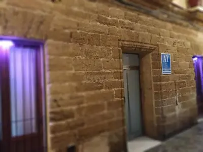 a brick wall with two doors in a building at GADEIRAS SUITES - Apartamentos Turísticos de 2 llaves in Cádiz