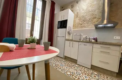 a kitchen with a table and a red counter top at GADEIRAS SUITES - Apartamentos Turísticos de 2 llaves in Cádiz