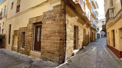 an alley in an old city with a brick building at GADEIRAS SUITES - Apartamentos Turísticos de 2 llaves in Cádiz