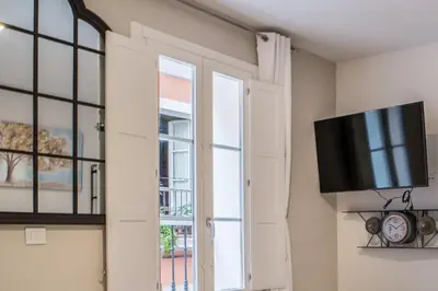 a living room with a tv and a window at Suite Capitán 3 in Cádiz