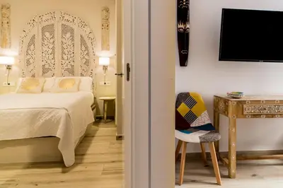 a bedroom with a bed and a table and a chair at Suite Capitán 1 in Cádiz