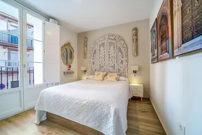 a bedroom with a bed and a large window at Suite Capitán 2 in Cádiz