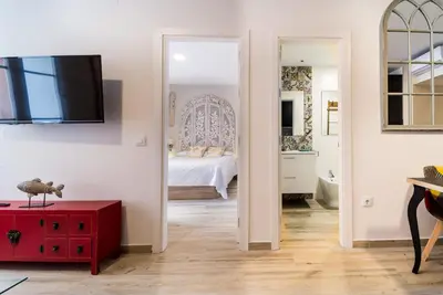 a bedroom with a bed and a red table in a room at Suite Capitán 2 in Cádiz