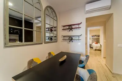 a dining room with a black table and chairs at Suite Capitán 2 in Cádiz