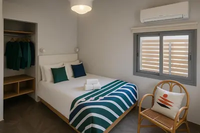 a bedroom with a bed and a chair and a window at Skyline - Penthouse with 50m2 private terrace and stunning views in Cádiz