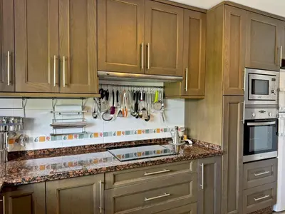 a kitchen with wooden cabinets and a counter top at Apartamento Esencia - Ole Solutions in Arcos de la Frontera