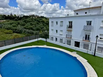 a large blue swimming pool in front of a building at Apartamento Esencia - Ole Solutions in Arcos de la Frontera