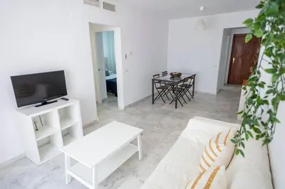 a living room with a white couch and a tv at GINVA - Apartamento con terraza en la ribera del río in El Puerto de Santa María