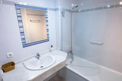 a white bathroom with a sink and a shower at GINVA - Apartamento con terraza en la ribera del río in El Puerto de Santa María