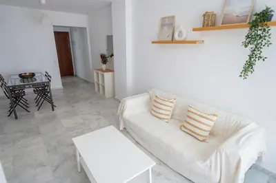 a living room with a white couch and a table at GINVA - Apartamento con terraza en la ribera del río in El Puerto de Santa María