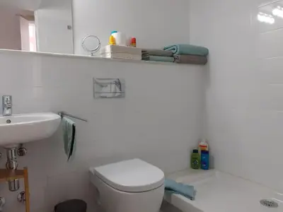 a white bathroom with a toilet and a sink at Los Balcones de Cádiz in Cádiz