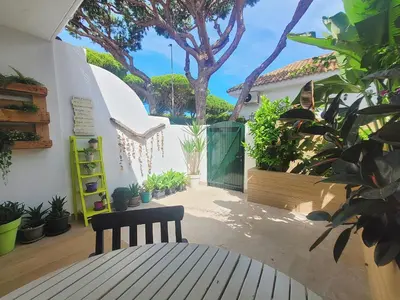a bench sitting in a courtyard with plants at Cozy Chalet - playa a 200m in Chiclana de la Frontera