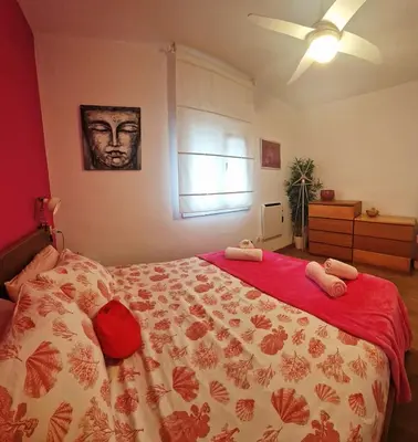 a bedroom with a large bed with a red blanket at Cozy Chalet - playa a 200m in Chiclana de la Frontera