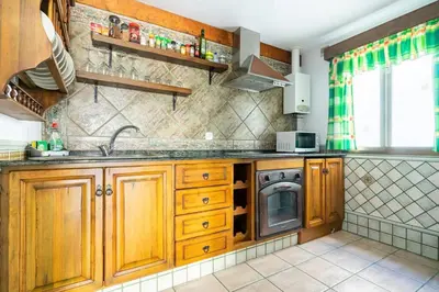 a kitchen with wooden cabinets and a sink at Junto al Mar in Chiclana de la Frontera