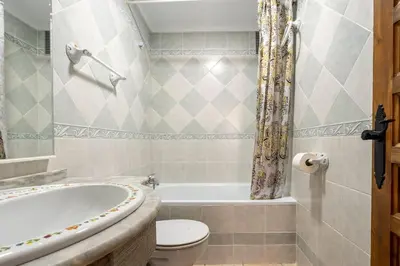 a bathroom with a tub and a toilet and a sink at Junto al Mar in Chiclana de la Frontera