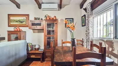 a dining room with a table with a vase of flowers at Villa Maymonis Chiclana de la Frontera by Ruralidays in Chiclana de la Frontera