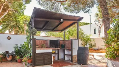 an outdoor kitchen with a grill in a backyard at Villa Maymonis Chiclana de la Frontera by Ruralidays in Chiclana de la Frontera
