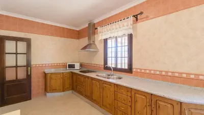 a large kitchen with a sink and a window at Casa San Nicolas Algar by Ruralidays in Algar