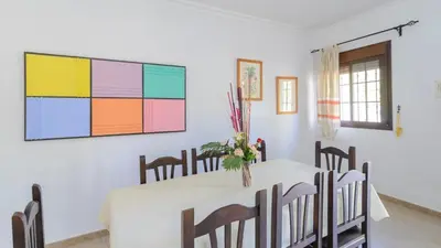 a dining room with a table with chairs and a painting on the wall at Casa San Nicolas Algar by Ruralidays in Algar