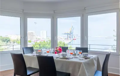 a table with chairs and wine glasses in a room with windows at Casa Hernán in Cádiz