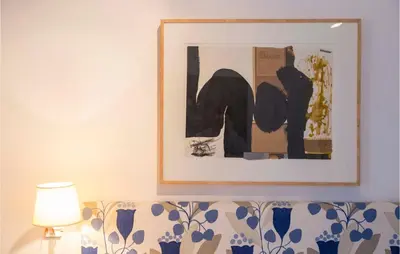 a picture on the wall above a couch with a lamp at Casa Hernán in Cádiz