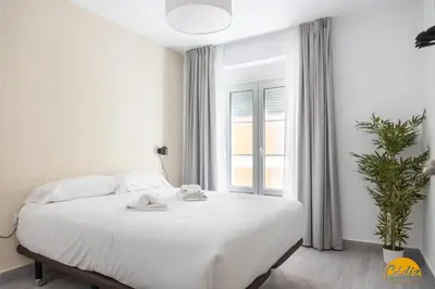 a bedroom with a white bed and a window at The House of Colors by Cadiz Time in Cádiz
