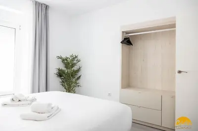a white bedroom with a bed with towels on it at The House of Colors by Cadiz Time in Cádiz