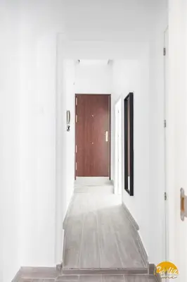 a hallway with a wooden door and white walls at The House of Colors by Cadiz Time in Cádiz