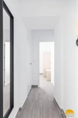 a hallway of a house with white walls and a mirror at The House of Colors by Cadiz Time in Cádiz