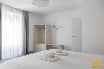 a white bedroom with two towels on a bed at The House of Colors by Cadiz Time in Cádiz