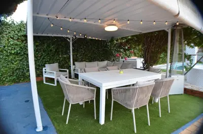 a white table and chairs under a white umbrella at EL ENCANTO Chiclana in Chiclana de la Frontera
