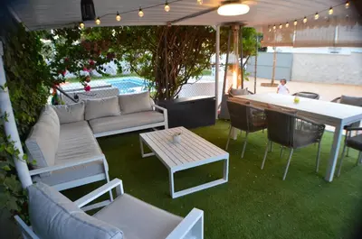 a patio with a couch and a table and chairs at EL ENCANTO Chiclana in Chiclana de la Frontera