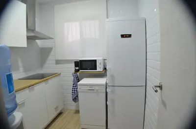 a white kitchen with a refrigerator and a microwave at EL ENCANTO Chiclana in Chiclana de la Frontera