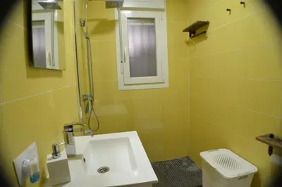 a yellow bathroom with a sink and a shower at EL ENCANTO Chiclana in Chiclana de la Frontera