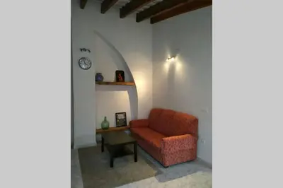 a living room with an orange chair and a table at Casa Florinda #7 in Jerez de la Frontera