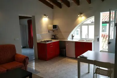 a kitchen with red cabinets and an arched window at Casa Florinda #7 in Jerez de la Frontera
