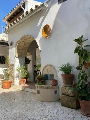 a white building with potted plants and an archway at Casa Florinda #7 in Jerez de la Frontera