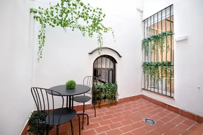 a patio with a table and chairs on a brick floor at Casa Maroca in Cádiz