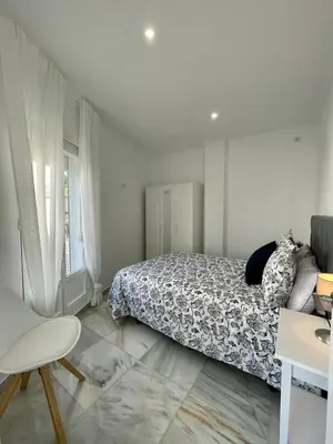 a white bedroom with a bed and a window at apartamentos la reina in Arcos de la Frontera