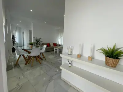 a living room with white walls and a table and chairs at apartamentos la reina in Arcos de la Frontera