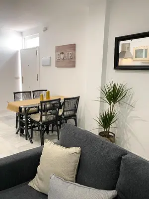a living room with a couch and a table with chairs at apartamentos la reina in Arcos de la Frontera
