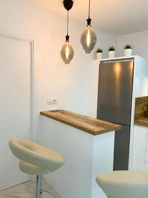a kitchen with a stainless steel refrigerator and pendant lights at apartamentos la reina in Arcos de la Frontera