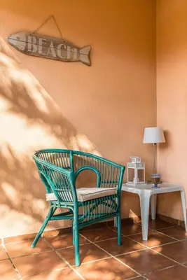 a green chair sitting next to a table with a lamp at Estupendo Adosado Urbanizacion Hoyo 12 Novo Sancti Petri in Chiclana de la Frontera