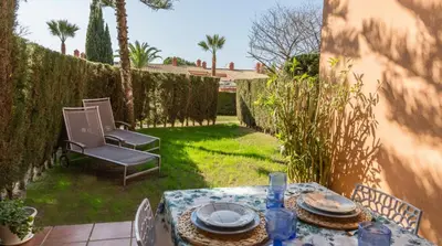 a table and chairs in a backyard with a table and chairs at Estupendo Adosado Urbanizacion Hoyo 12 Novo Sancti Petri in Chiclana de la Frontera