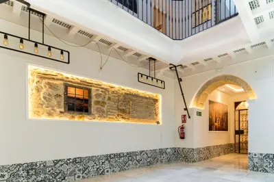 a room with a stone wall with a painting on the wall at Fabio Catedral I in Cádiz
