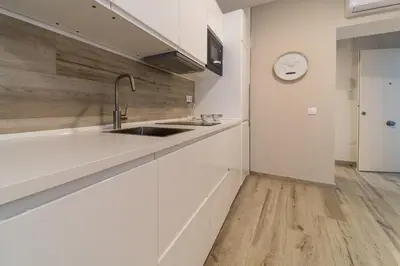 a kitchen with a sink and a clock on the wall at Fabio Catedral I in Cádiz