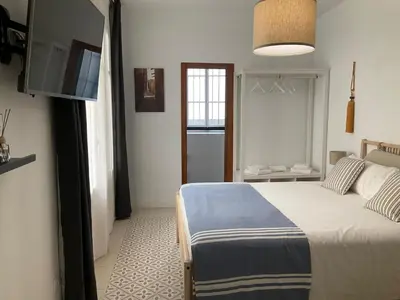 a bedroom with a bed and a flat screen tv at Casa de las Especias Hotel Boutique in Sanlúcar de Barrameda