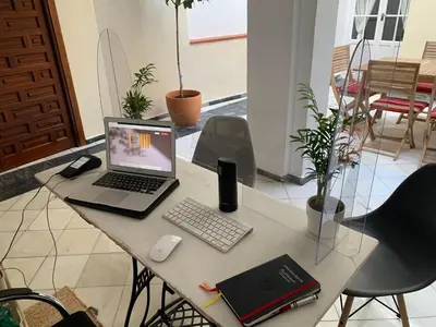 a desk with a laptop computer and a keyboard and mouse at Casa de las Especias Hotel Boutique in Sanlúcar de Barrameda