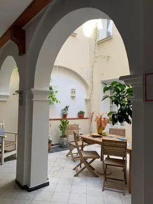 an archway in a patio with a table and chairs at Casa de las Especias Hotel Boutique in Sanlúcar de Barrameda