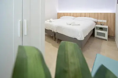 a bedroom with a white bed and a white table at Jardines de Candelaria Cadiz in Cádiz